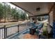 Cozy covered porch with seating, a fire pit, and scenic views of the surrounding woods at 5382 S Pine Rd, Evergreen, CO 80439
