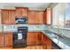 Well appointed kitchen featuring granite countertops, black appliances, and stainless steel sink at 471 N Jackson Gap Way, Aurora, CO 80018