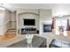 Open living area with fireplace, media center, and stairs leading to second story with hardwood and carpet flooring at 471 N Jackson Gap Way, Aurora, CO 80018