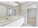 This bathroom features a double sink with white cabinets, a large mirror, and neutral walls at 598 Crossing Cir, Castle Pines, CO 80108