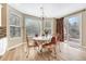 Bright dining area featuring a table with seating for six near windows and a sliding glass door at 598 Crossing Cir, Castle Pines, CO 80108