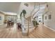 Bright foyer featuring a curved staircase, light hardwood floors, and a view to the adjacent formal dining room at 598 Crossing Cir, Castle Pines, CO 80108
