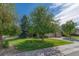 Well-maintained front yard with lush green grass, mature trees, and a charming curb appeal at 598 Crossing Cir, Castle Pines, CO 80108