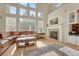 Bright living room boasts high ceilings, large windows, hardwood floors, fireplace and a comfortable leather couch at 598 Crossing Cir, Castle Pines, CO 80108