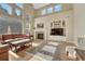 Bright living room with a fireplace, large windows, built-in shelves, and hardwood floors at 598 Crossing Cir, Castle Pines, CO 80108