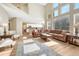 Spacious living room with high ceilings, large windows, hardwood floors, and a view into the kitchen at 598 Crossing Cir, Castle Pines, CO 80108