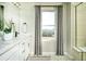 Bright bathroom with a white double sink vanity and a window with mountain views at 3325 N Coolidge Way, Aurora, CO 80019