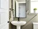 Stylish powder room featuring a pedestal sink, modern fixtures, and decorative paneling at 3325 N Coolidge Way, Aurora, CO 80019