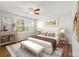 Bright bedroom with a ceiling fan, large window and stylish decor create a relaxing and inviting atmosphere at 2872 Jasmine St, Denver, CO 80207