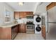 Well-equipped kitchen featuring stainless steel appliances and a convenient stacked laundry unit at 2872 Jasmine St, Denver, CO 80207