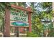 Charming Peak Eight Village sign surrounded by lush greenery and mature trees at 1080 Ski Hill Rd # 9, Breckenridge, CO 80424