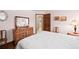 Cozy bedroom featuring a white quilt, wood furniture, and a door leading to the bathroom at 3151 E 134Th Cir, Thornton, CO 80241