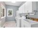 Bright laundry room with white cabinets, a sink, and a window with backyard views at 30455 Telluride Ln, Evergreen, CO 80439