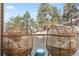 Outdoor deck featuring egg-shaped patio chairs and views of the surrounding forest at 30455 Telluride Ln, Evergreen, CO 80439