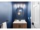 Stylish powder room featuring navy blue walls and a wood vanity at 30455 Telluride Ln, Evergreen, CO 80439