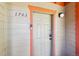 Front door of unit 1703 with new smart lock and neutral siding with orange trim at 283 Pelican Cir # 1703, Breckenridge, CO 80424