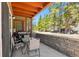 Covered patio featuring a grill, patio table, retaining wall, and views of the wooded area at 283 Pelican Cir # 1703, Breckenridge, CO 80424