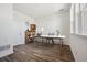 Bright home office features wood floors, built-in shelving, white walls and a modern desk near a window at 6940 Merseyside Ln, Castle Pines, CO 80108