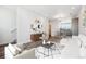 Open-concept living room with view of dining area features modern furnishings and decorative art on the wall at 6940 Merseyside Ln, Castle Pines, CO 80108