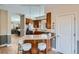 Open kitchen with an island, counter seating, wood cabinets, and stainless steel appliances at 821 S High St, Denver, CO 80209