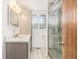 Updated bathroom features a vanity, quartz countertop, and a tiled shower with glass door at 1923 Ensenada Ct, Aurora, CO 80011