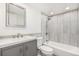 Modern bathroom features a vanity with stylish mirror, tiled shower and tub, and toilet at 1923 Ensenada Ct, Aurora, CO 80011
