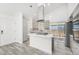 Bright kitchen featuring a center island with cooktop, sleek countertops, and stainless steel refrigerator at 1923 Ensenada Ct, Aurora, CO 80011