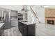 Open concept kitchen featuring stone fireplace and center island with cooktop, refrigerator and double oven at 1923 Ensenada Ct, Aurora, CO 80011