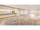 Open basement space featuring a bar area with white cabinets and stainless steel refrigerator at 2905 Morningbird Ln, Castle Rock, CO 80109