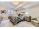 Cozy bedroom with a patterned comforter, side tables, and a window with blinds at 2905 Morningbird Ln, Castle Rock, CO 80109