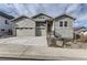 Two-story house with gray siding, stone accents, and a two-car garage at 2905 Morningbird Ln, Castle Rock, CO 80109