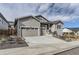 Two-story house with gray siding, stone accents, and a two-car garage at 2905 Morningbird Ln, Castle Rock, CO 80109