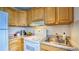 Galley kitchen with white appliances and wood cabinets at 4800 E Hale Pkwy # 709N, Denver, CO 80220