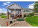 Charming home featuring a walkout basement, deck with stairs, landscaped backyard, and lush lawn at 22166 E Chestnut Pl, Aurora, CO 80016