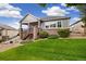 Charming home featuring a walkout basement, deck with stairs, landscaped backyard, and lush lawn at 22166 E Chestnut Pl, Aurora, CO 80016