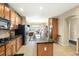 Spacious kitchen features wooden cabinetry, black appliances, and a large island with granite countertops at 22166 E Chestnut Pl, Aurora, CO 80016