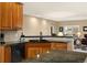 Kitchen area featuring granite countertops, wooden cabinets, and stainless steel dishwasher at 22166 E Chestnut Pl, Aurora, CO 80016