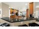 Open-plan view into the kitchen from the living room, featuring dark countertops and wood cabinetry at 22166 E Chestnut Pl, Aurora, CO 80016