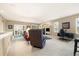 Spacious carpeted living room with plush seating, a wall-mounted TV, and access to natural light from large windows at 22166 E Chestnut Pl, Aurora, CO 80016
