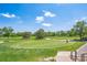 Scenic view of a golfer on the green, set against a backdrop of mature trees and a clear blue sky at 584 Ridgeview Dr, Louisville, CO 80027