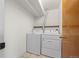 Practical laundry area with a washer and dryer, storage shelves, and tile flooring for easy maintenance at 584 Ridgeview Dr, Louisville, CO 80027