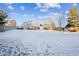 Large backyard with a deck, wooden fence, and snow-covered lawn at 2786 E 118Th Cir, Thornton, CO 80233
