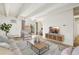 Bright living room featuring wood floors, white ceiling beams, and comfortable furniture at 100 S Clarkson St # 304, Denver, CO 80209