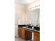 Well-lit bathroom featuring a dark countertop, ample lighting, and a large mirror for functionality and style at 5861 Mt Shadows Blvd, Firestone, CO 80504