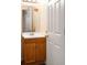 Bathroom with wood vanity, stylish mirror, and a white door leading to other spaces at 5861 Mt Shadows Blvd, Firestone, CO 80504