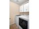 Laundry room equipped with white front-loading washing machine and dryer, and upper cabinets at 5861 Mt Shadows Blvd, Firestone, CO 80504