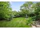 Spacious backyard with mature trees, lush landscaping, and an outdoor dining area, perfect for entertaining and relaxation at 9045 W Ithaca Pl, Denver, CO 80235