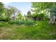 Lush backyard with vibrant flowers and mature trees surrounding the home, creating a tranquil outdoor space at 9045 W Ithaca Pl, Denver, CO 80235