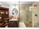 Elegant bathroom featuring a glass-enclosed shower, stone tile, and a vanity with ample storage at 9045 W Ithaca Pl, Denver, CO 80235