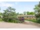 A beautiful, private, ranch-style home behind a wrought iron gate and mature landscaping at 9045 W Ithaca Pl, Denver, CO 80235